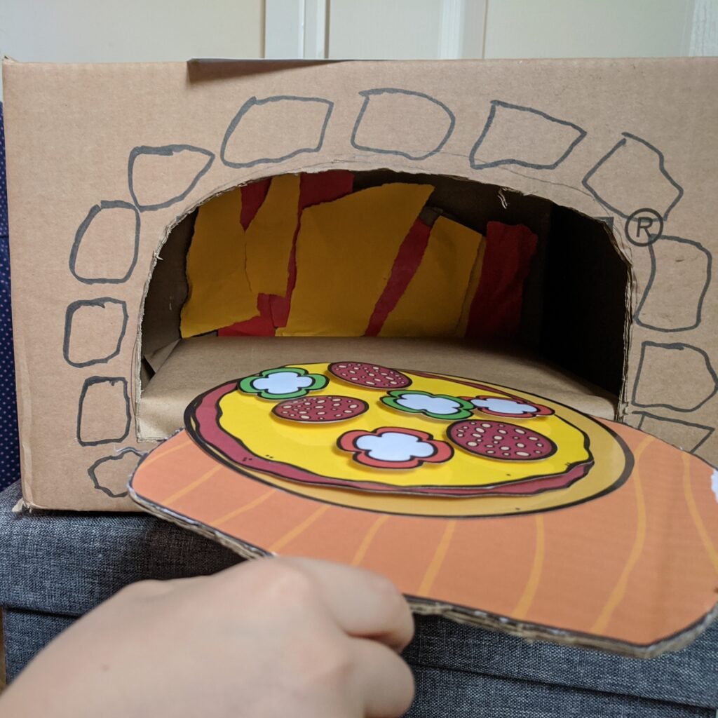 dramatic play pizza oven made from a cardboard box